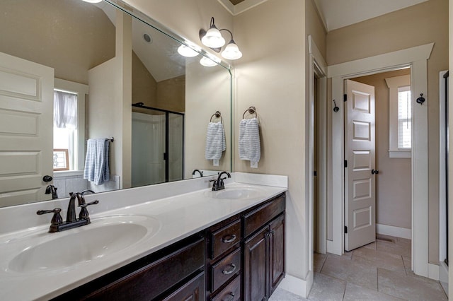 bathroom featuring a sink, baseboards, a stall shower, and double vanity