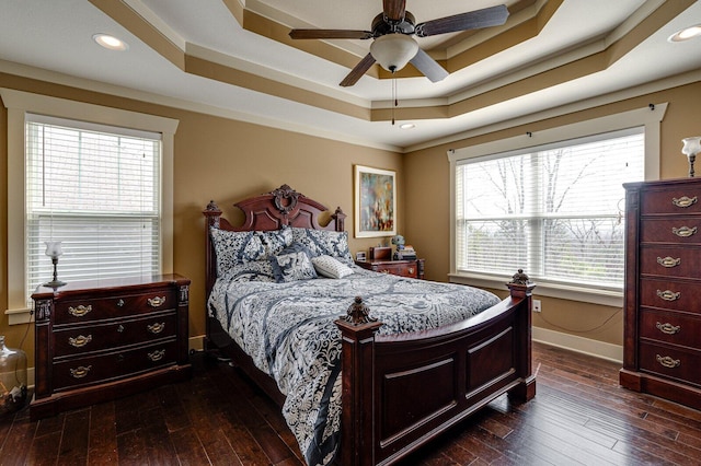 bedroom featuring dark wood-style floors, recessed lighting, baseboards, and a tray ceiling