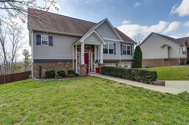 view of front facade featuring a front yard, fence, and brick siding