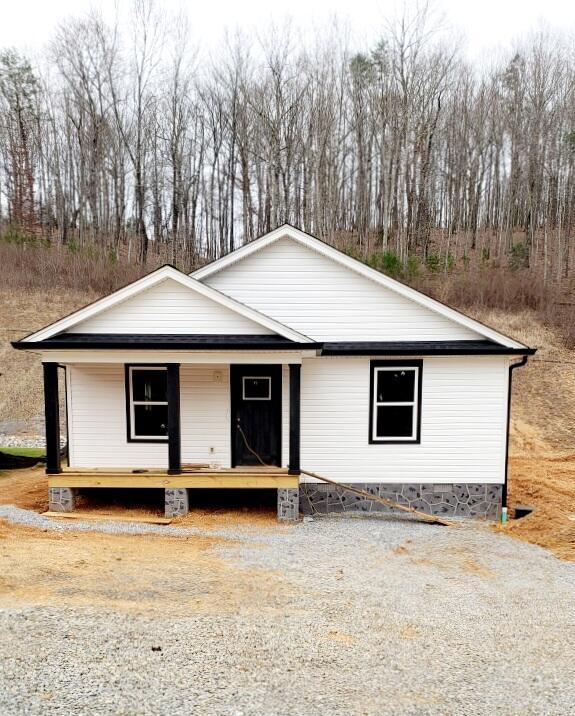 view of front facade with a porch and gravel driveway