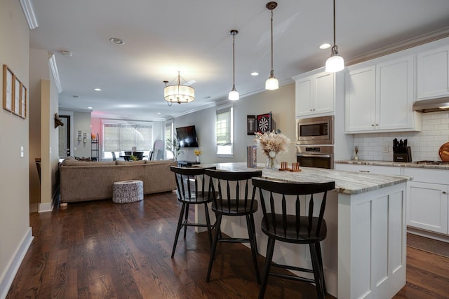 kitchen with under cabinet range hood, tasteful backsplash, stainless steel appliances, and a wealth of natural light