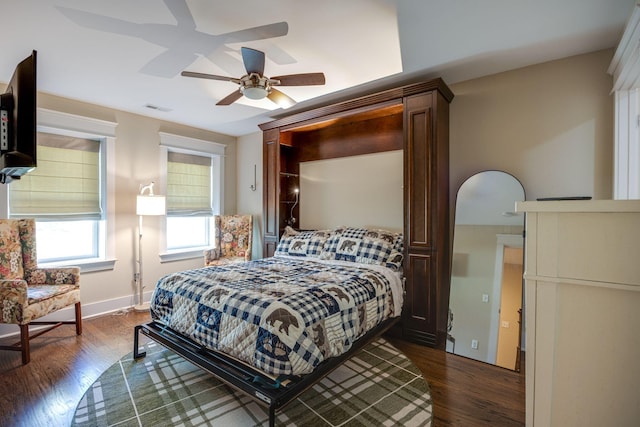 bedroom featuring visible vents, dark wood finished floors, baseboards, and ceiling fan