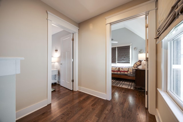 corridor featuring dark wood finished floors and baseboards