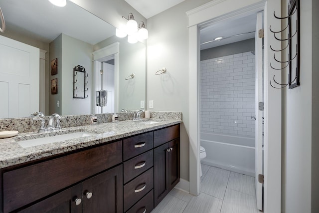 bathroom with tile patterned flooring, a sink, toilet, and double vanity