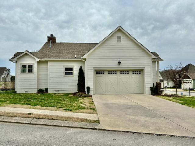 view of front of property featuring fence, concrete driveway, an attached garage, crawl space, and a chimney