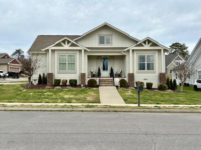 craftsman house with a porch and a front lawn