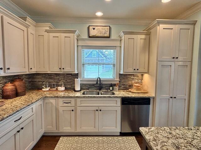 kitchen featuring a sink, stainless steel dishwasher, crown molding, decorative backsplash, and light stone countertops