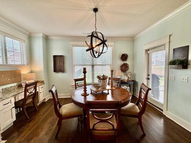 dining area with crown molding, dark wood-type flooring, baseboards, built in desk, and a notable chandelier