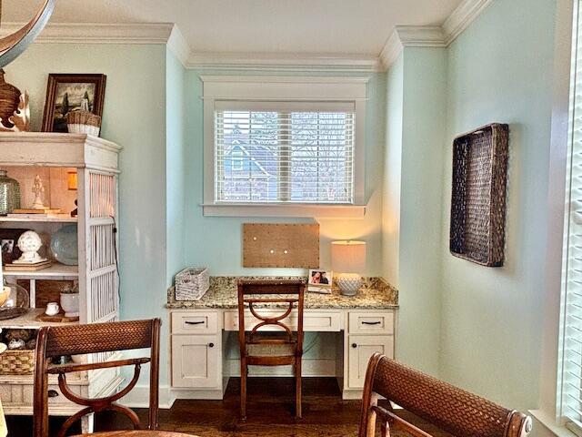 office area with dark wood finished floors, built in study area, and ornamental molding