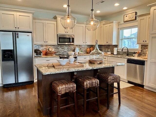 kitchen with decorative backsplash, crown molding, dark wood-style floors, and stainless steel appliances