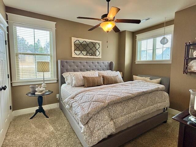 bedroom with multiple windows, carpet, and baseboards