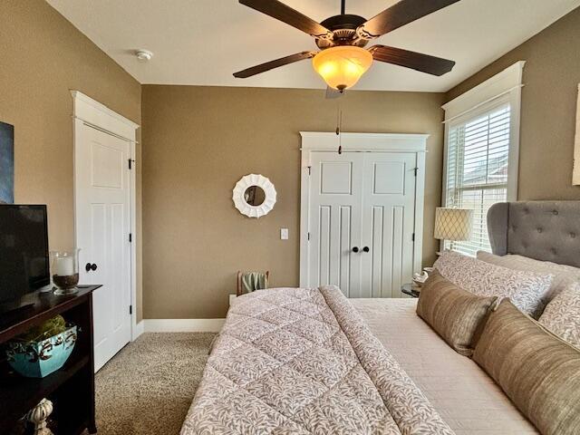 bedroom featuring baseboards, a closet, carpet floors, and ceiling fan