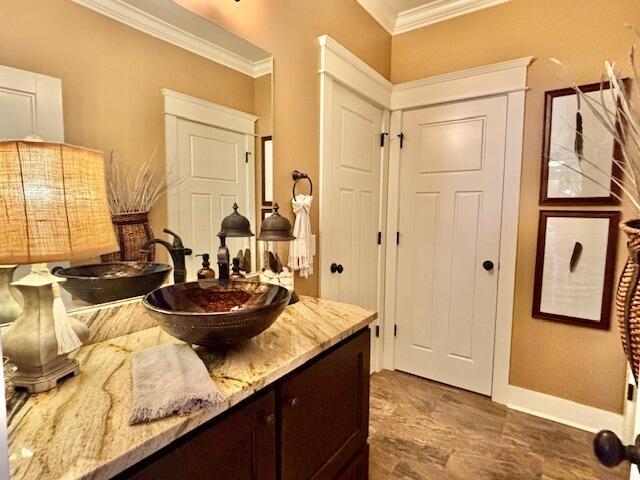 bathroom featuring vanity, baseboards, and ornamental molding