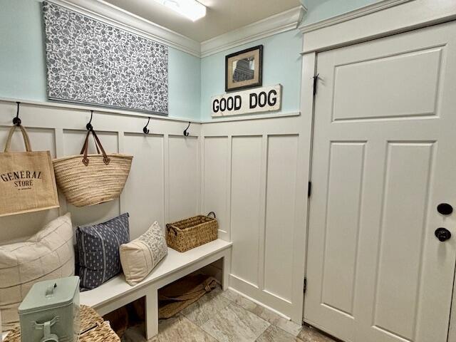 mudroom featuring a decorative wall, wainscoting, and ornamental molding