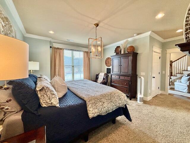 carpeted bedroom featuring a chandelier, recessed lighting, baseboards, and ornamental molding