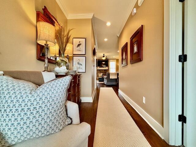 corridor with crown molding, recessed lighting, wood finished floors, and baseboards