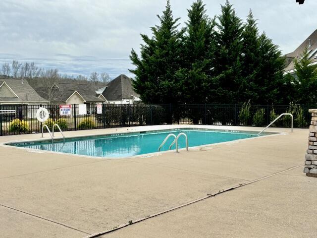 community pool featuring a patio area and fence