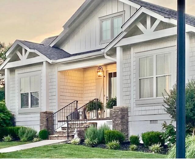 property entrance with board and batten siding and a shingled roof