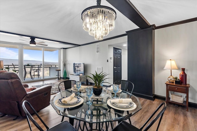 dining room with visible vents, ceiling fan with notable chandelier, wood finished floors, crown molding, and baseboards