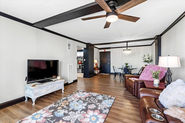 living room with baseboards, wood finished floors, crown molding, and ceiling fan with notable chandelier