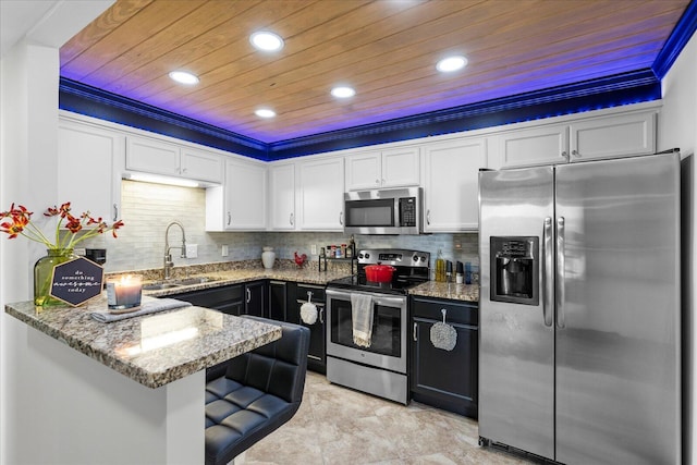 kitchen with light stone counters, stainless steel appliances, crown molding, white cabinetry, and wooden ceiling