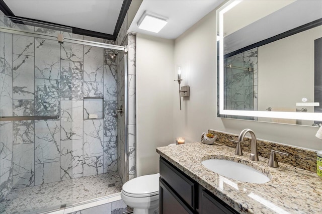 full bath featuring a marble finish shower, toilet, ornamental molding, and vanity