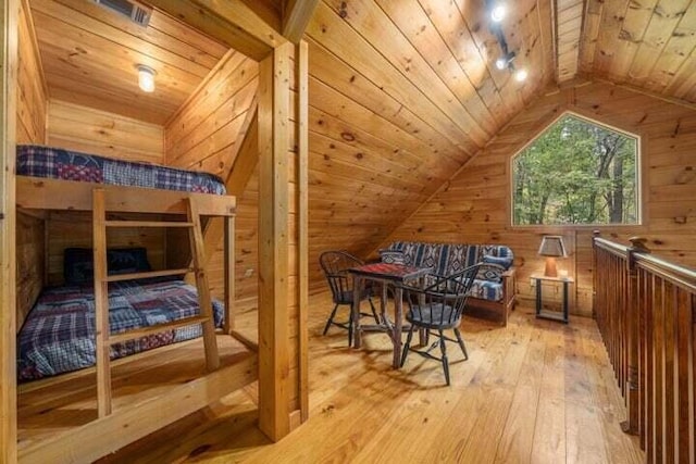 bedroom featuring wooden ceiling, wooden walls, light wood-type flooring, and lofted ceiling