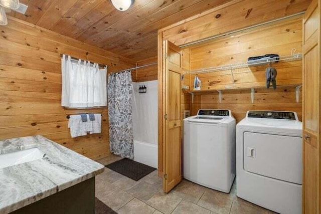 laundry area featuring laundry area, wood walls, and washing machine and clothes dryer