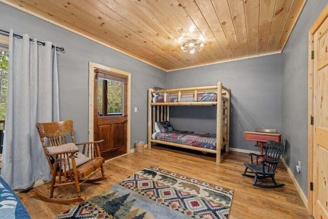 bedroom featuring multiple windows, wood ceiling, baseboards, and wood finished floors