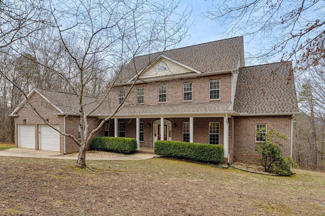 view of front of property featuring brick siding, concrete driveway, a front yard, covered porch, and an attached garage