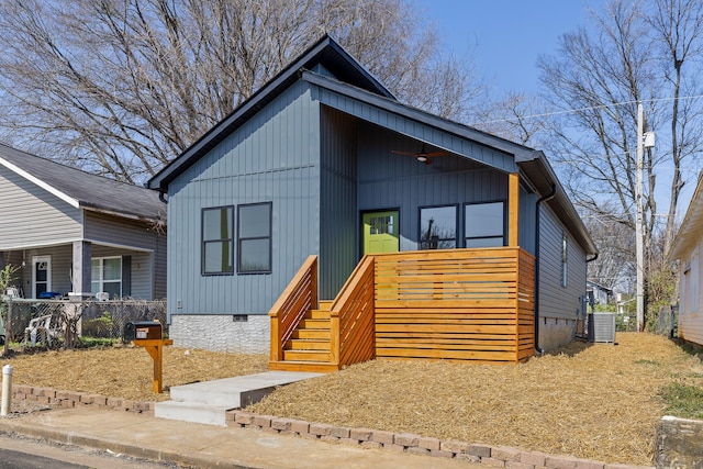 view of front of home with crawl space, central AC, and fence