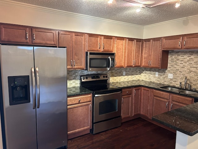 kitchen with a sink, a textured ceiling, dark wood finished floors, appliances with stainless steel finishes, and crown molding