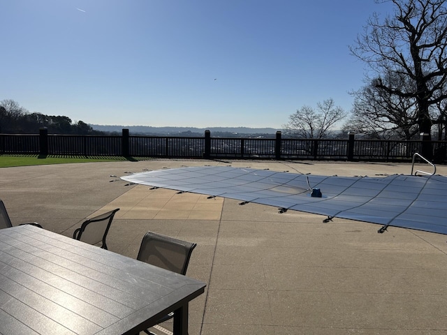 view of swimming pool with outdoor dining space, fence, a mountain view, a fenced in pool, and a patio area