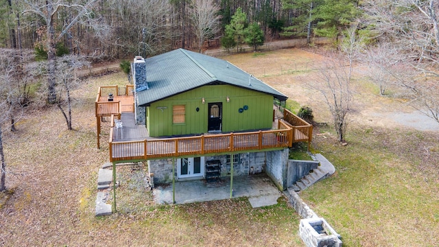 exterior space with french doors, a chimney, a patio area, and a wooden deck