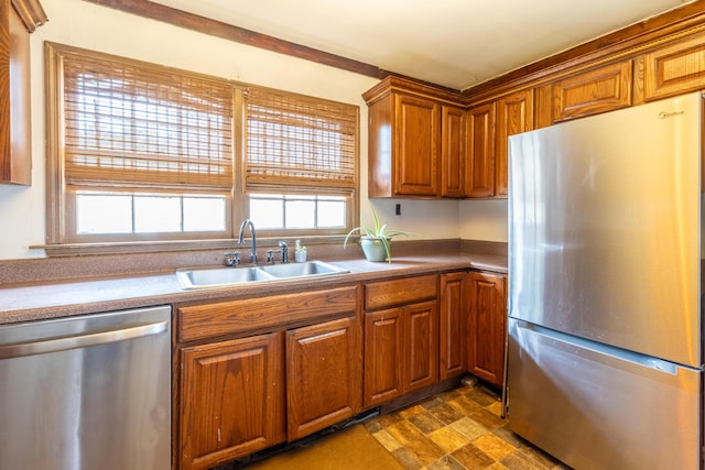 kitchen featuring appliances with stainless steel finishes, brown cabinetry, and a sink