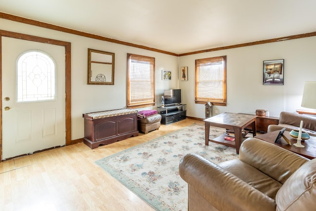 living room with light wood-style floors, ornamental molding, and a wealth of natural light