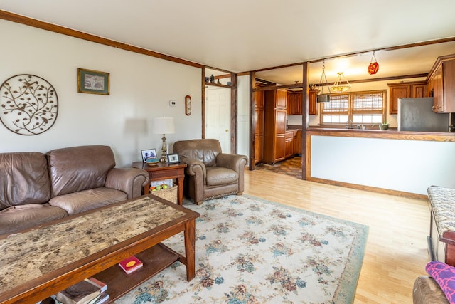 living room with crown molding and light wood-style floors