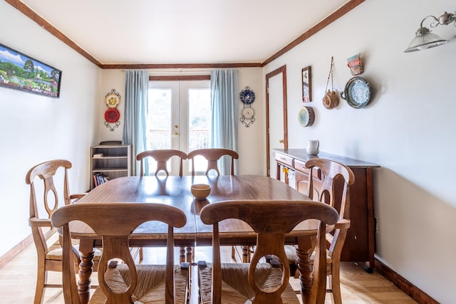 dining space featuring ornamental molding, french doors, light wood-style flooring, and baseboards