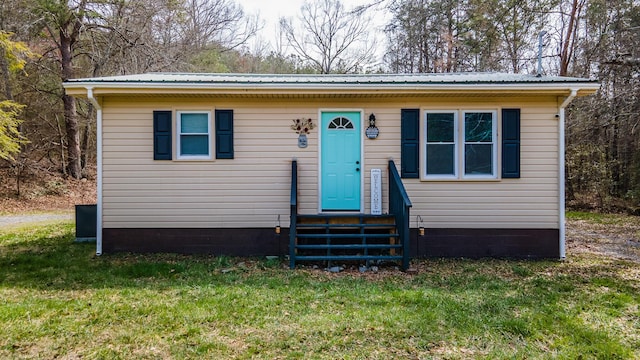 bungalow-style house with entry steps, a front yard, and metal roof