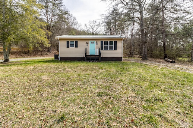 view of front of property featuring metal roof, a front lawn, and entry steps