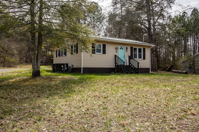 view of front of house featuring central AC unit, entry steps, and a front lawn