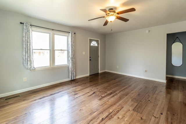 interior space with ceiling fan, visible vents, baseboards, and hardwood / wood-style floors