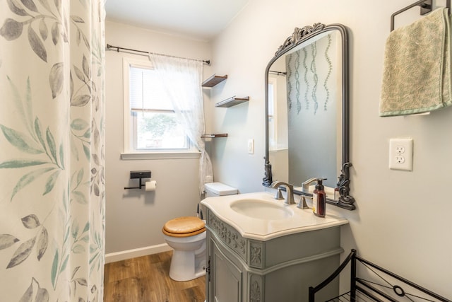 bathroom with a shower with curtain, toilet, wood finished floors, baseboards, and vanity