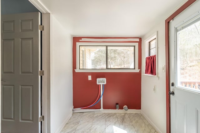 laundry room with baseboards, marble finish floor, and a healthy amount of sunlight