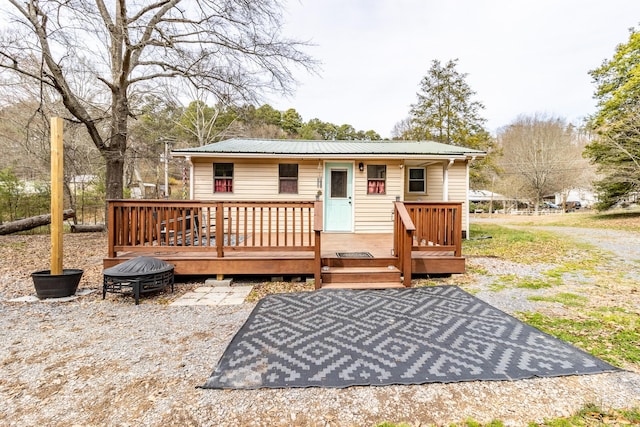 exterior space with a deck, an outdoor fire pit, and metal roof