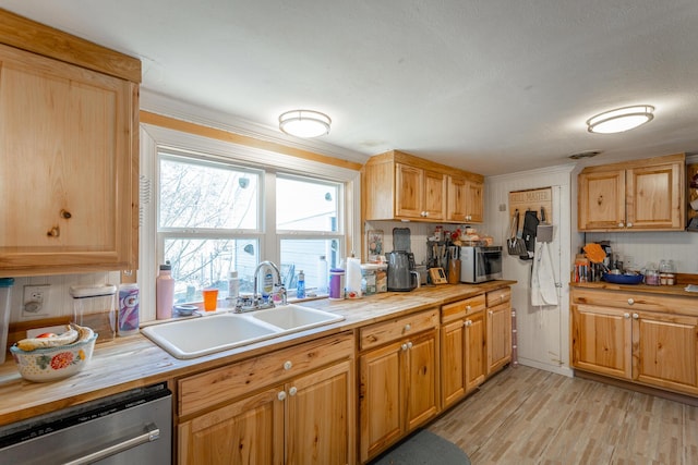 kitchen with light wood-style flooring, a sink, appliances with stainless steel finishes, crown molding, and wooden counters