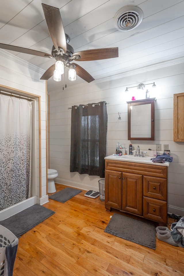 full bathroom featuring toilet, a shower with curtain, wood finished floors, and visible vents