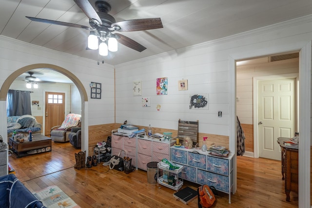 interior space with hardwood / wood-style flooring, arched walkways, and ornamental molding