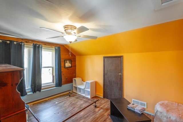 additional living space with a ceiling fan, lofted ceiling, wood finished floors, and visible vents