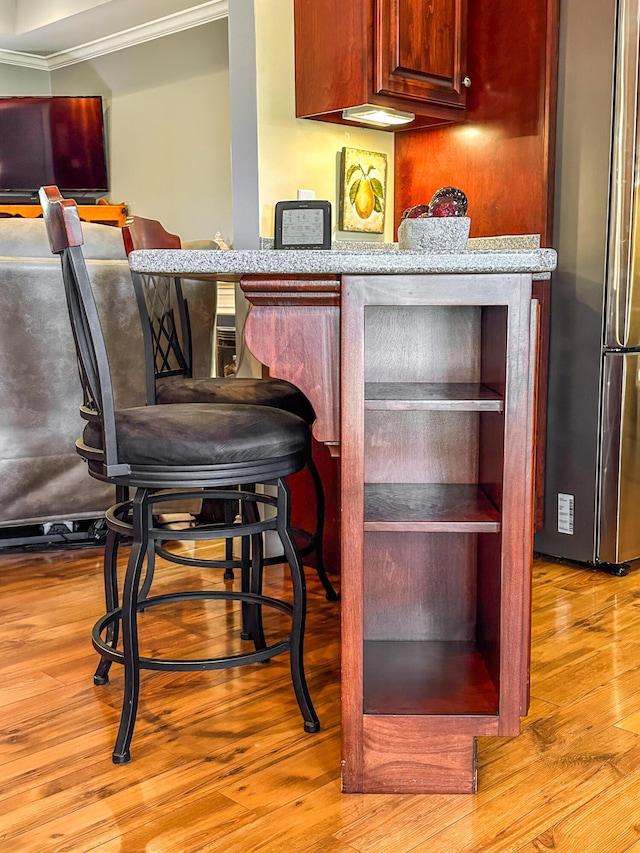 bar with wood finished floors and freestanding refrigerator